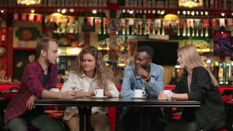 Four-people-in-a-coffee-shop-are-talking-and-smiling-Multi-ethnic-couples.