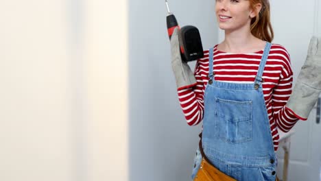 woman holding screw gun at home 4k