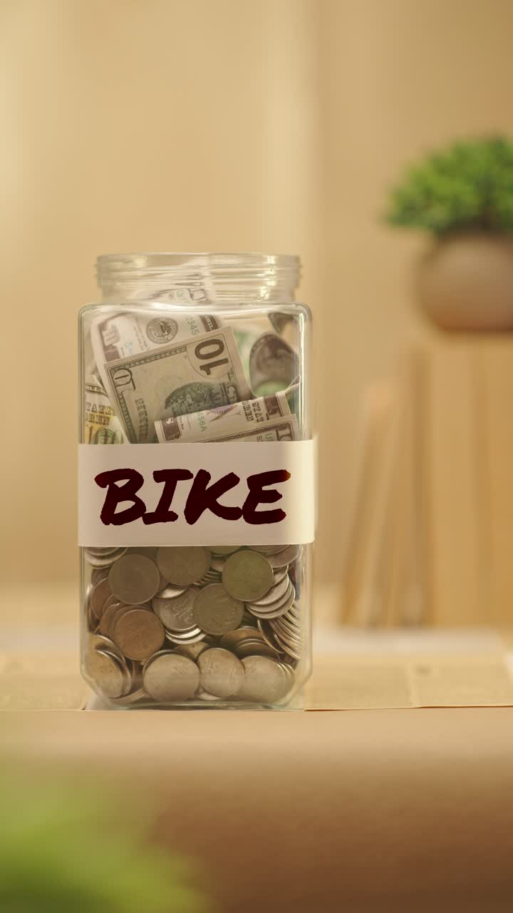 VERTICAL VIDEO OF PERSON SAVING MONEY FOR BIKE