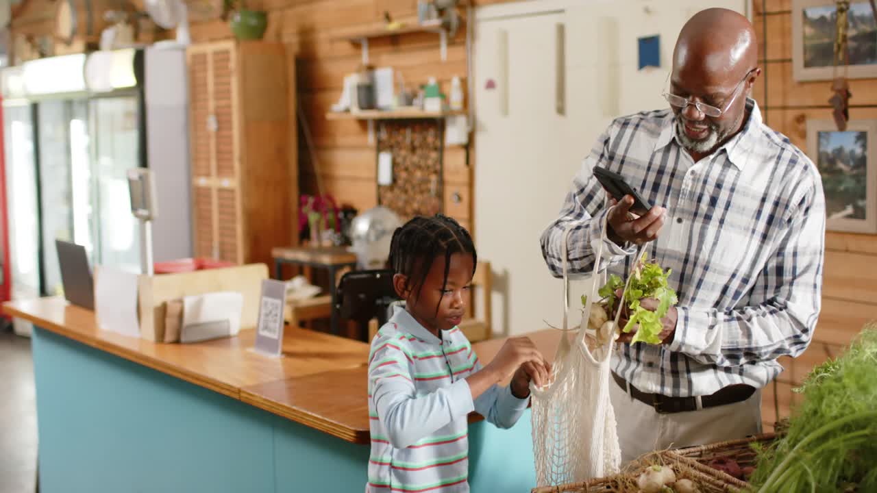 Happy senior african american grandfather and grandson shopping at health food shop, slow motion