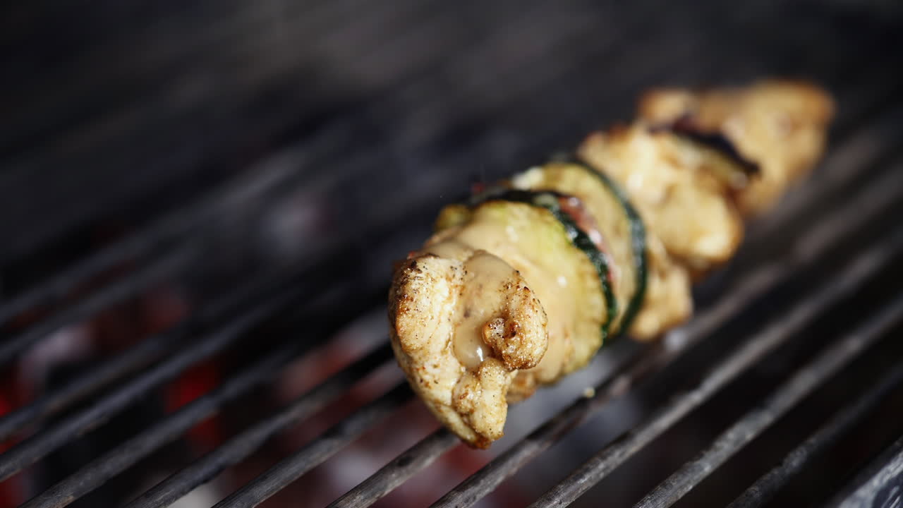 Grilling Juicy And Delicious Chicken Meat With Cucumbers On A Skewer Over Hot Charcoal On A Grill - Closeup Shot