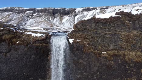 Waterfall-on-snowy-cliff-in-winter