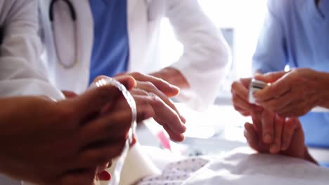 doctor placing electronic pulse clip on patients finger