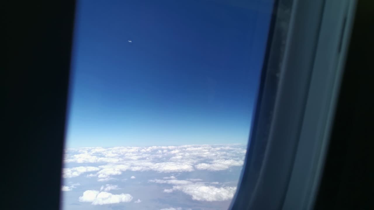 ver fuera de la ventana de un avión con otro avión volando en la misma dirección cerca