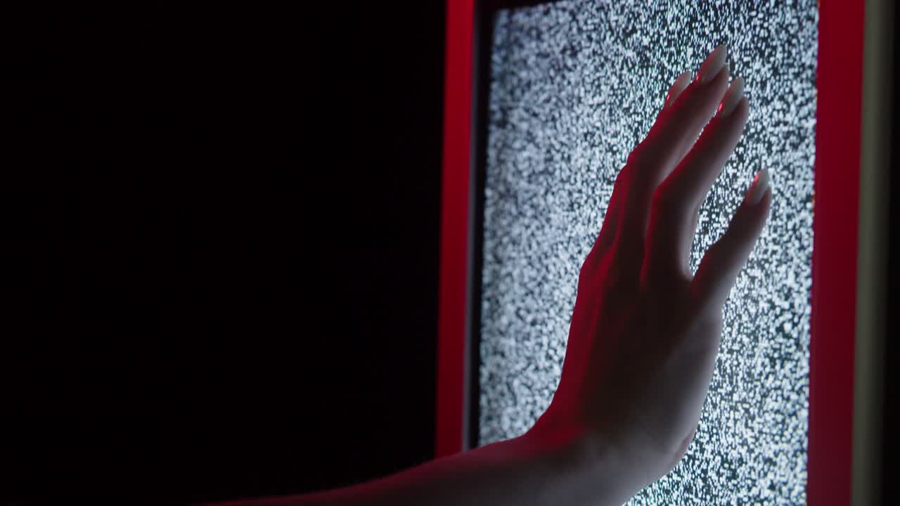 mano humana tocando vieja pantalla de televisión retro con ondas, señal ondulada dañada. primer plano de televisión anticuada rota con ruido, mala recepción de señal, concepto de cinematografía