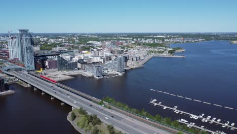 Automobile-and-train-commuters-cross-Kulosaari-Bridge-in-Helsinki,-FIN