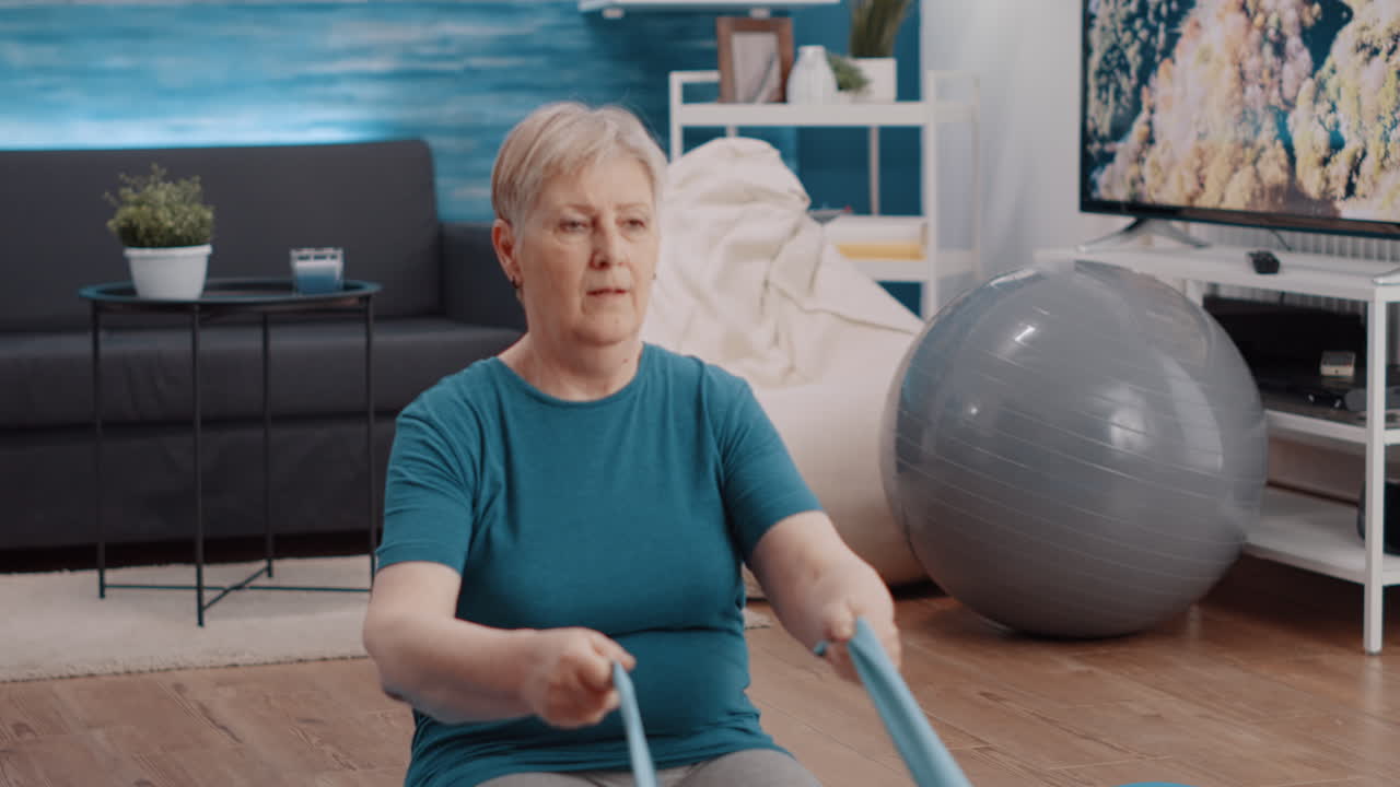 Close up of pensioner training with resistance band at home