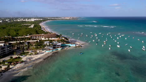 Tiro-De-Drone-Giratorio-De-Barcos-En-El-Océano-Y-La-Costa-En-Playa-Del-Carmen-México