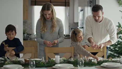 Caucasian-marriage-with-children-preparing-table-for-Christmas-Eve.