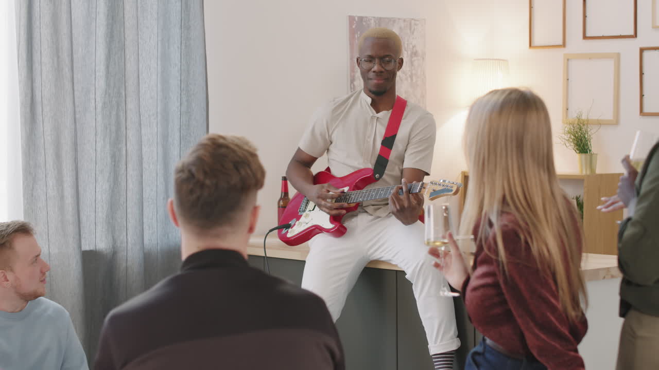 Man Playing Electric Guitar at Get-Together with Friends