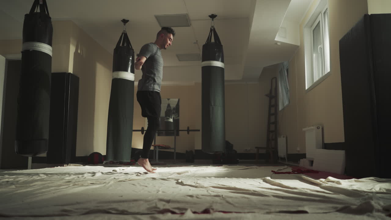 복싱 체육관에서 연습하는 로프 점프. 젊은 박서가 전투 클럽에서 슬로우 모션에서 스 로프를 점프합니다. 피트니스 장비를 가진 운동 선수