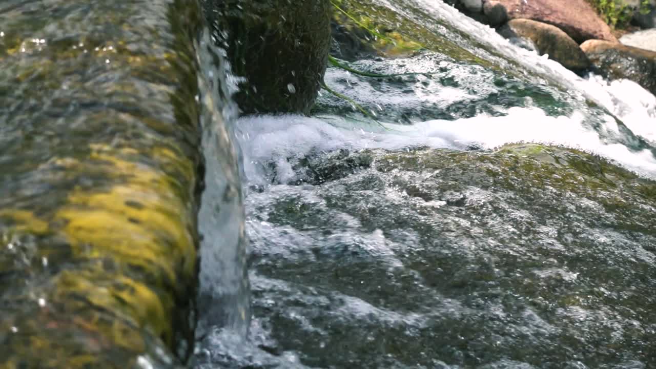 Acqua che scorre da una cascata al rallentatore, panoramica a destra.