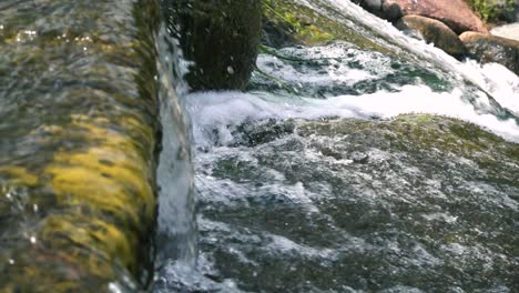 Water-flowing-down-a-waterfall-in-slow-motion,-panning-to-the-right