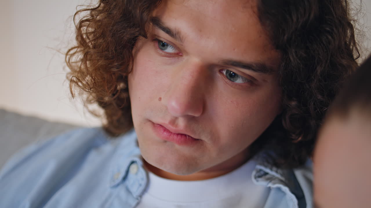 Calm spouses looking TV show at peaceful family evening closeup. Portrait man