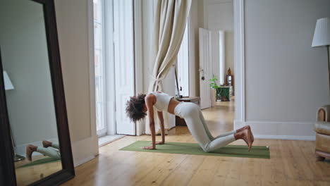 Mujer-Deportiva-Estirando-La-Estera-Del-Cuerpo-En-El-Interior.-Modelo-Africano-Calentando-Músculos