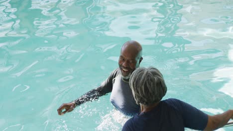 video of happy senior african american couple swimming in pool
