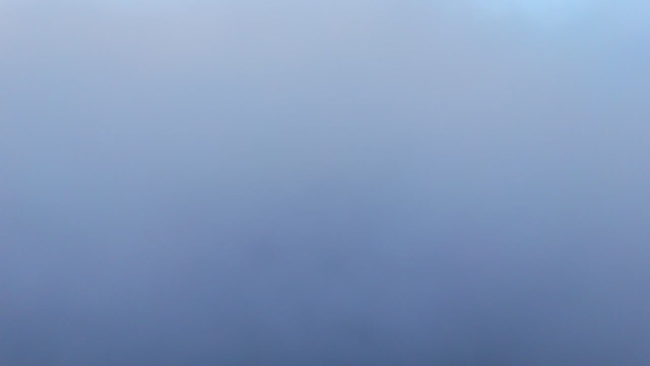 Ampia vista aerea di nuvole spesse e soffici che formano un mare sotto, cielo azzurro sereno con fasce di nuvole stratificate e luce diurna soffusa vicino all'orizzonte, ideale per viaggi da sogno e immagini di sfondo