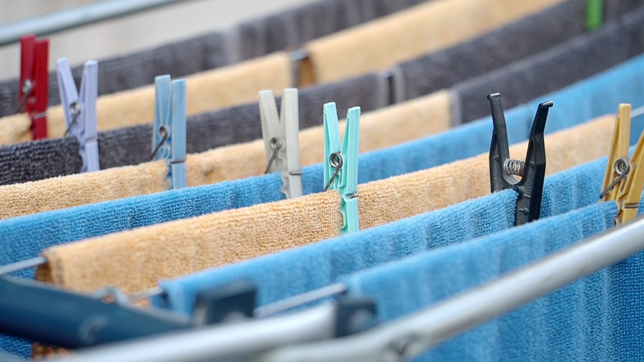 Colorful Towels Hanging on a Clothes Drying Rack with Clothespins