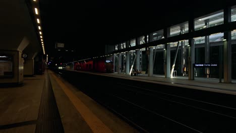 train arrives at turin station during nighttime