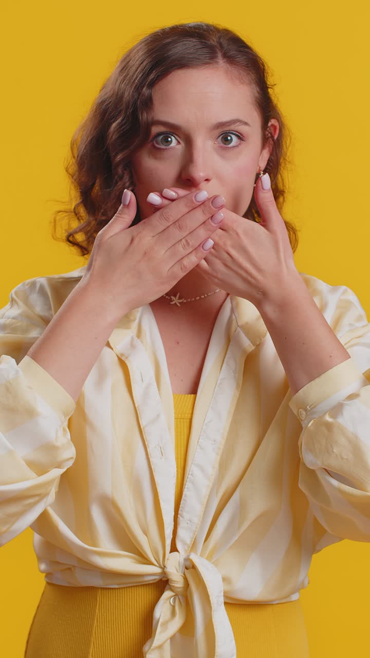 Frightened woman closing mouth with hands refusing to tell terrible secret unbelievable truth