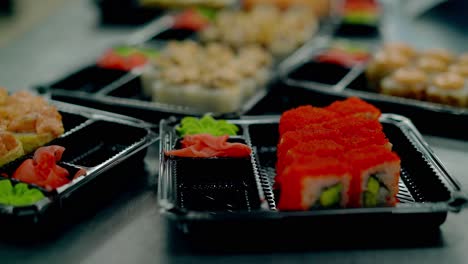 Cook-serves-Japanese-rolls-with-caviar-of-flying-fish-adds-wasabi