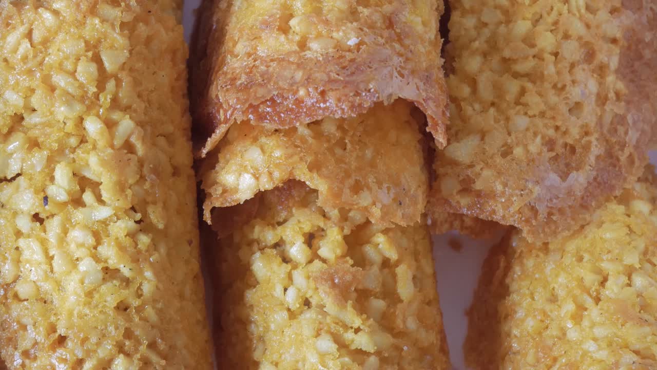 Close-up shot of crunchy almond Tejas cookies, highlighting their texture and golden hue under soft lighting