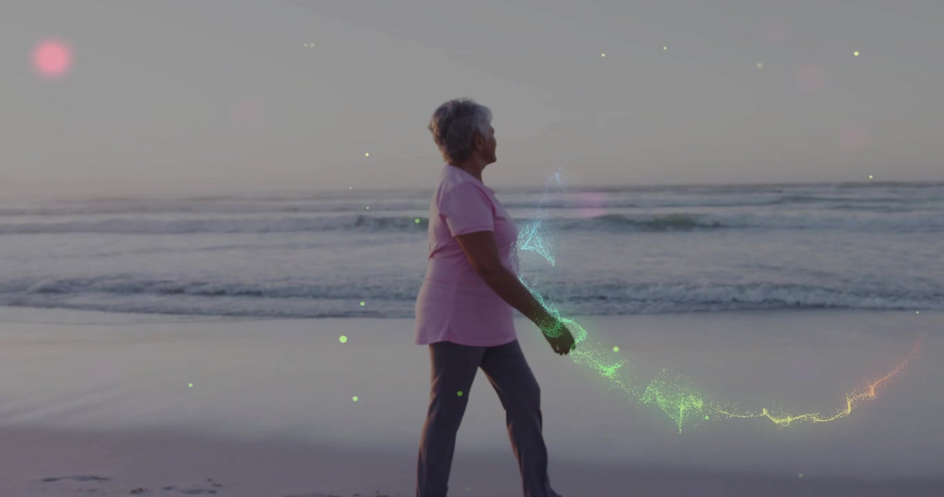 Donna anziana che cammina sulla sabbia bagnata e passeggia lungo la riva con bagliori al neon che turbinano in un'atmosfera di benessere