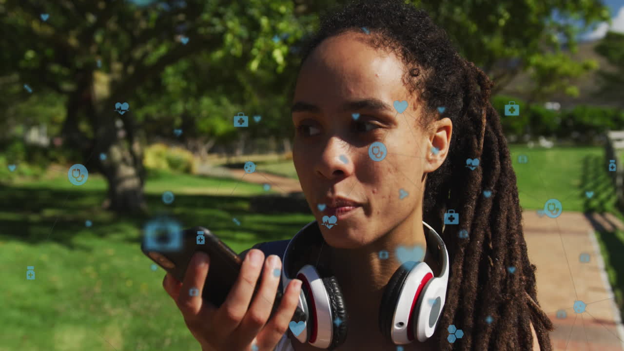 Animation of medical icons over biracial woman talking on smartphone