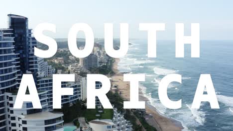 Drone-Shot-Of-Coastline-With-Ocean-And-Beach-Resort-Overlaid-With-Animated-Graphic-Spelling-Out-South-Africa