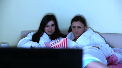 young women watching horror movie together