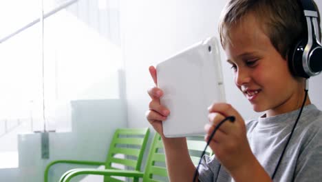 Boy-using-digital-tablet-in-hospital-corridor