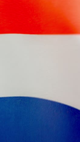 Vertical video of dutch national flag waving by the wind