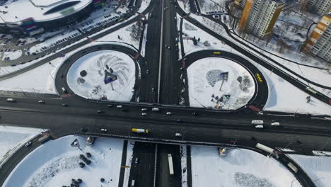 Autobahnkreuz-In-Der-Winterstadt.-Luftaufnahme-Eines-Autos,-Das-Auf-Einem-Kreisverkehr-Fährt