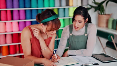 dos mujeres discutiendo un proyecto de diseño en una tienda de hilo