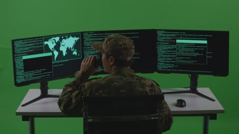 vista posteriore di un uomo asiatico soldato sviluppatore che beve caffè e usa il computer per scrivere codice con più schermi in green screen studio