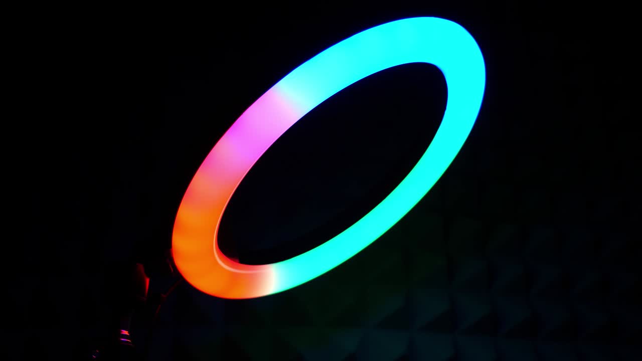 Luminous ring rgb lamp. Multicolored light in a dark room, close-up.