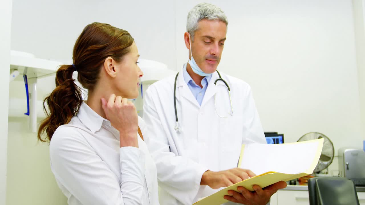 dentista discutiendo el informe con una paciente femenina