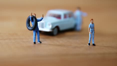 miniature mechanic changing a punctured tyre