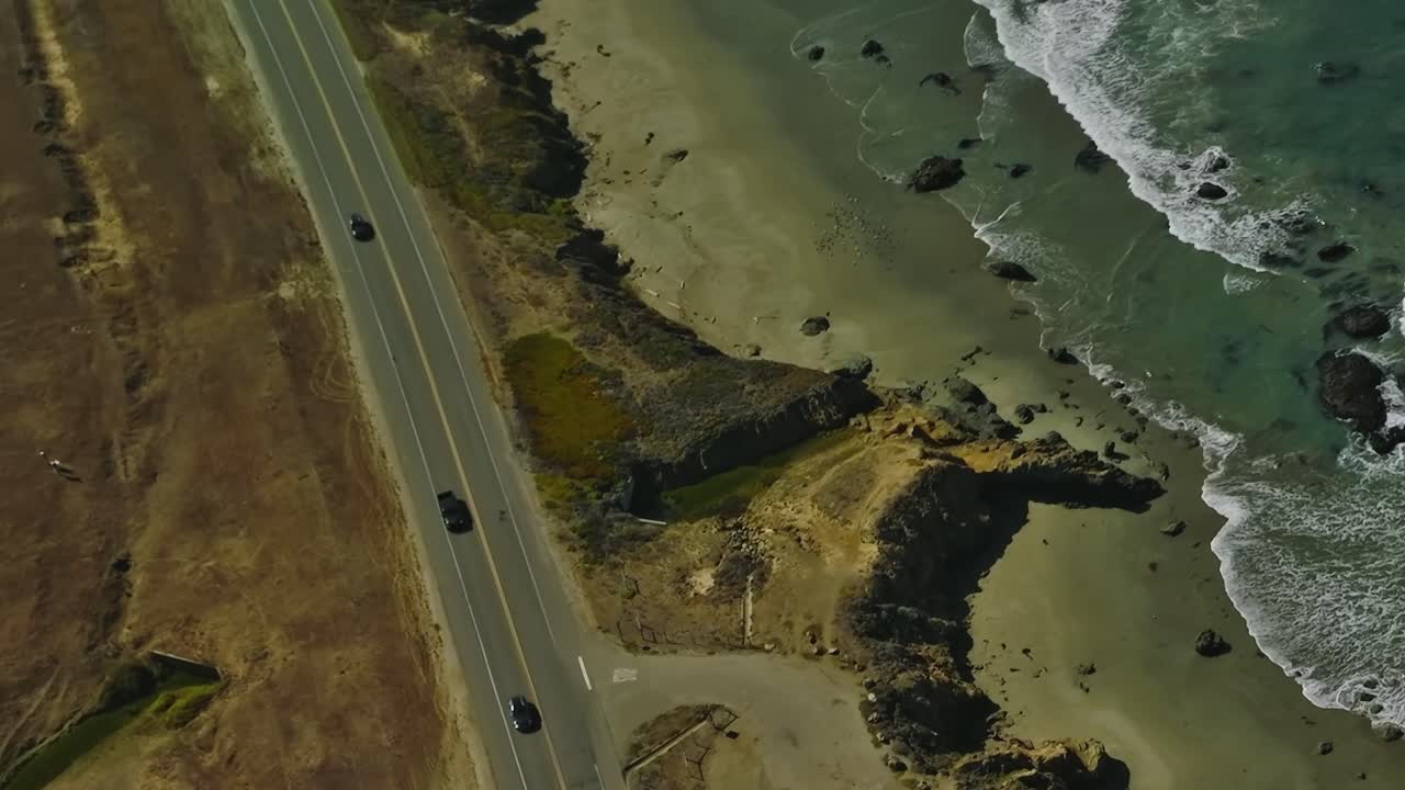 Kystmotorvej snor sig langs en sandstrand i Californien, USA