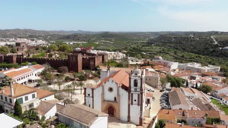 pull-away, 4k aerial drone footage revealing surrounding area around the historical silves cathedral of the tourist destination town of silves, portugal