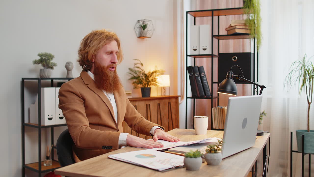 Businessman works at home office desk looking at bills paperwork reports throws documents in air