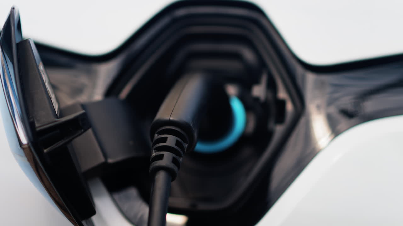 Close up of an electric car charger plugged into a white car