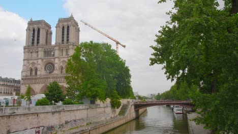 reconstruction of the iconic notre-dame de paris cathedral in paris, france with view of pont au double over the seine river