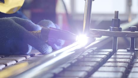 closeup of man wearing mask welding in a workshop. metal workers use manual labor. skilled welder. welder is welding the stainless steel pipes in the factory. welder industrial part in factory.