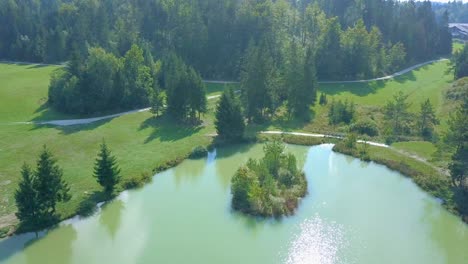 Aerial-drone-view-of-small-islands-on-a-lake-at-a-rural-recreation-area-at-Lake-Cerknica,-river-Rak