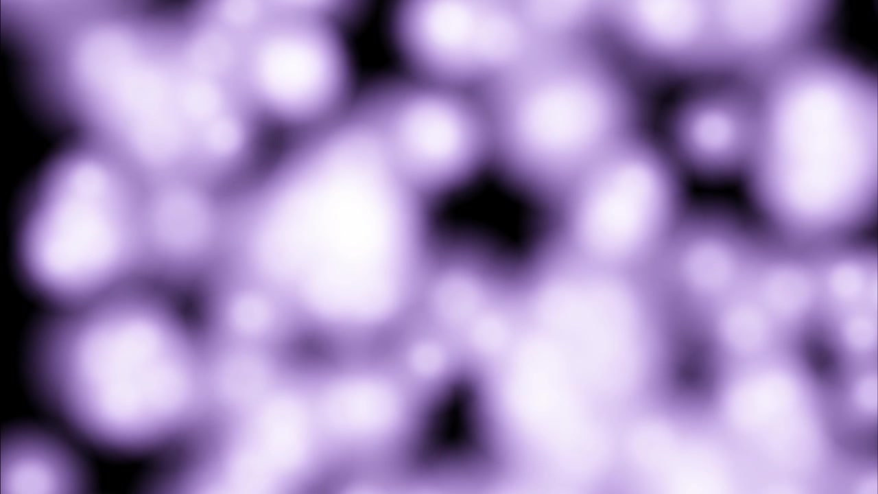 Abstrakt animation med glødende lilla partikler, der driver gennem blød bokeh-sløring på sort baggrund, hvilket skaber sømløse atmosfæriske visuals til kreative digitale projekter.