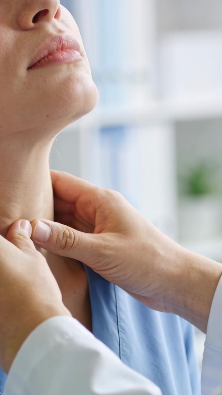 Video verticale: Clinico in camice bianco che palpa il collo del paziente, con le mani che entrano da destra in clinica.