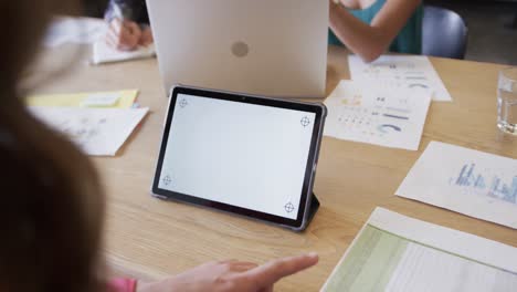 tableta con espacio de copia en la pantalla y diversos colegas en discusión en la oficina casual, cámara lenta