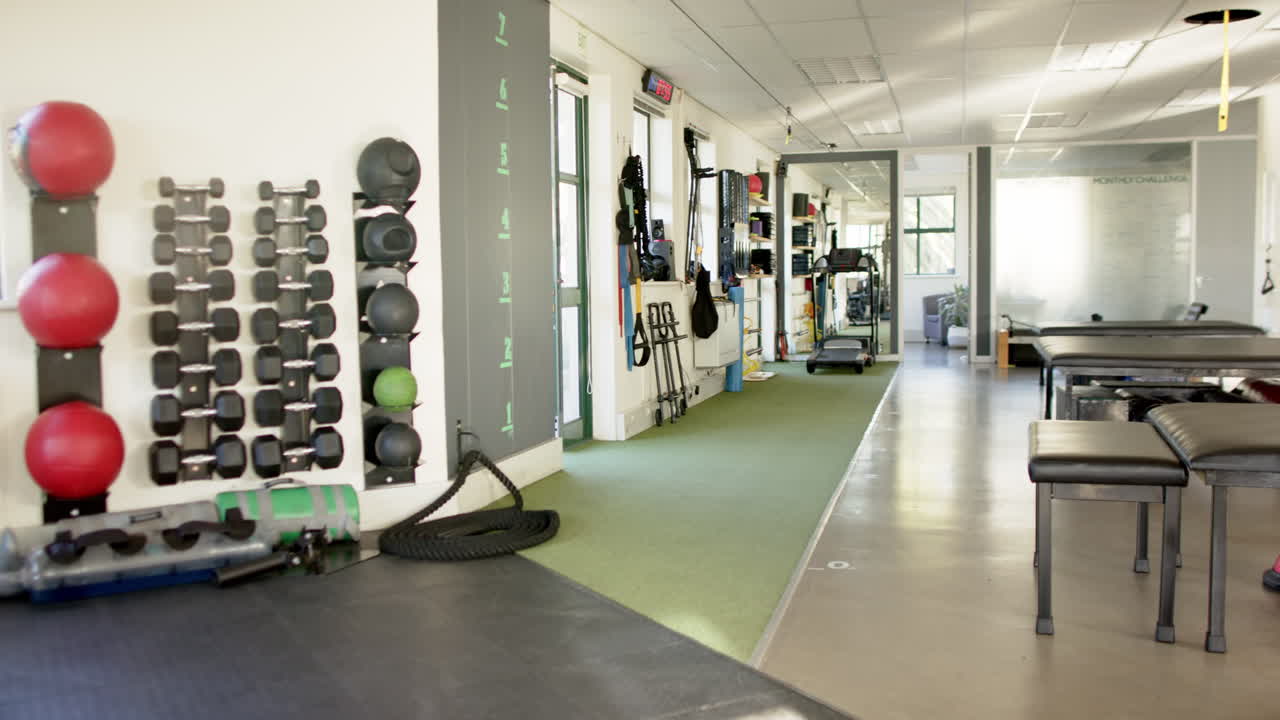 Rehabilitation center with exercise equipment and therapy tables for disability rehab, copy space