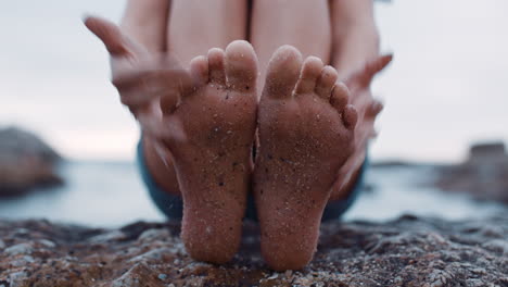 close up of sandy feet young woman sitting on beach barefoot enjoying summer vacation